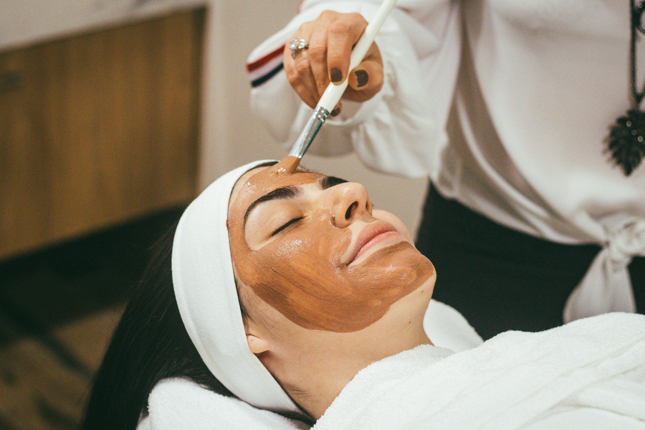 A provider performing an aesthetic skin treatment on a relaxed patient